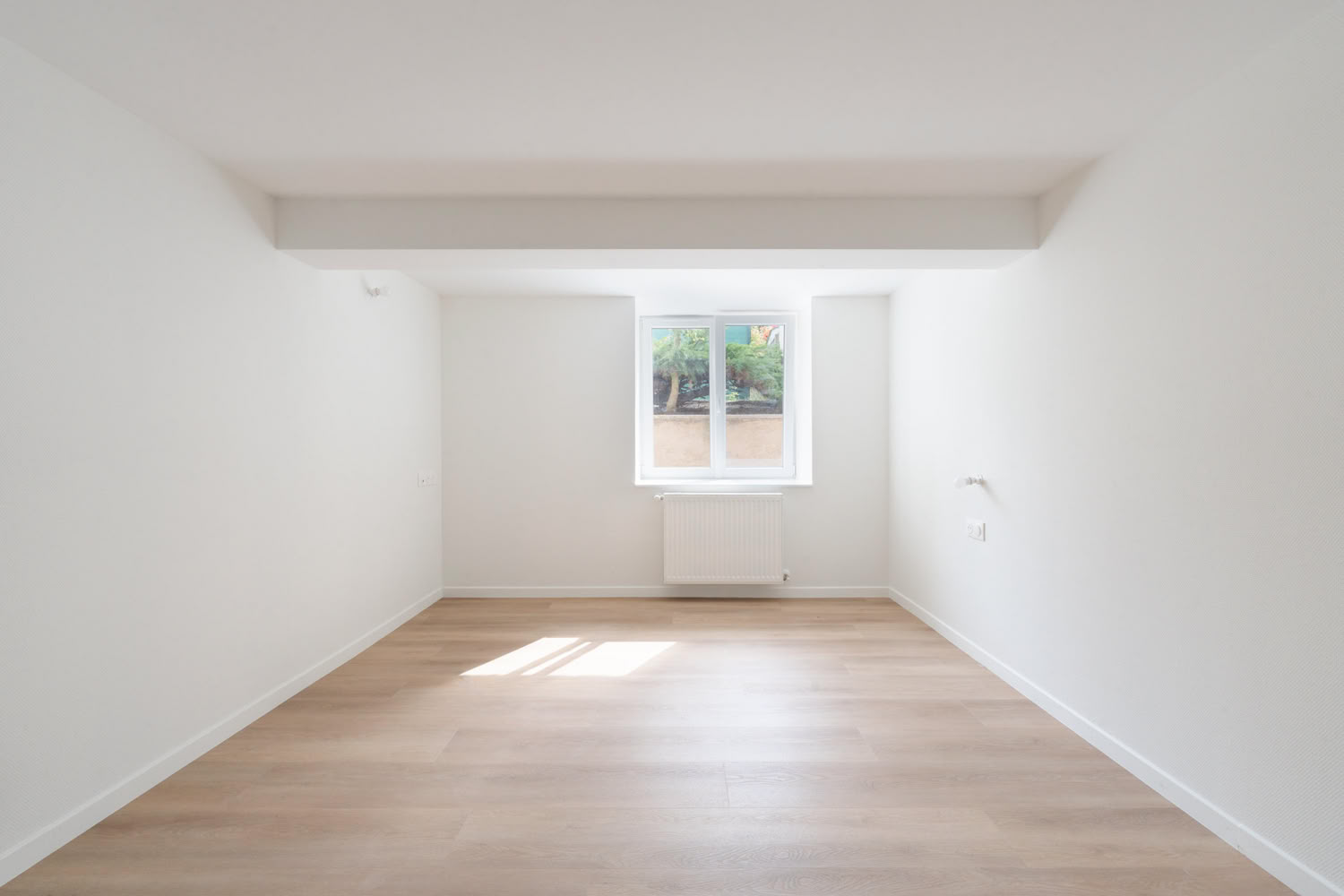 Rénovation d'une chambre lumineuse avec parquet LVT chêne et murs blancs, architecte d'intérieur à Metz.
