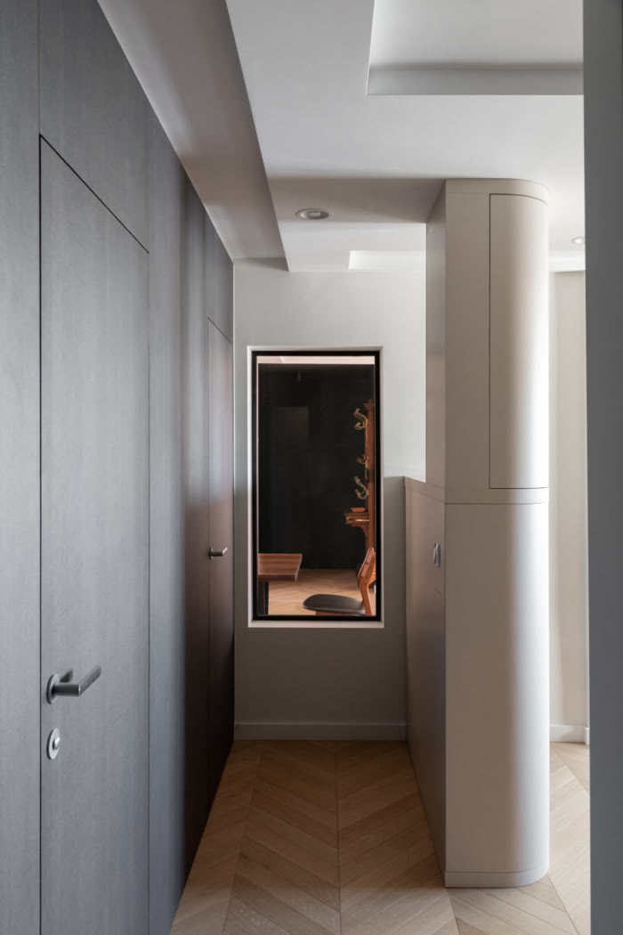 Optimisation d'un couloir avec un meuble TV sur mesure intégré, transformant un lieu de passage en espace de rangement élégant.
