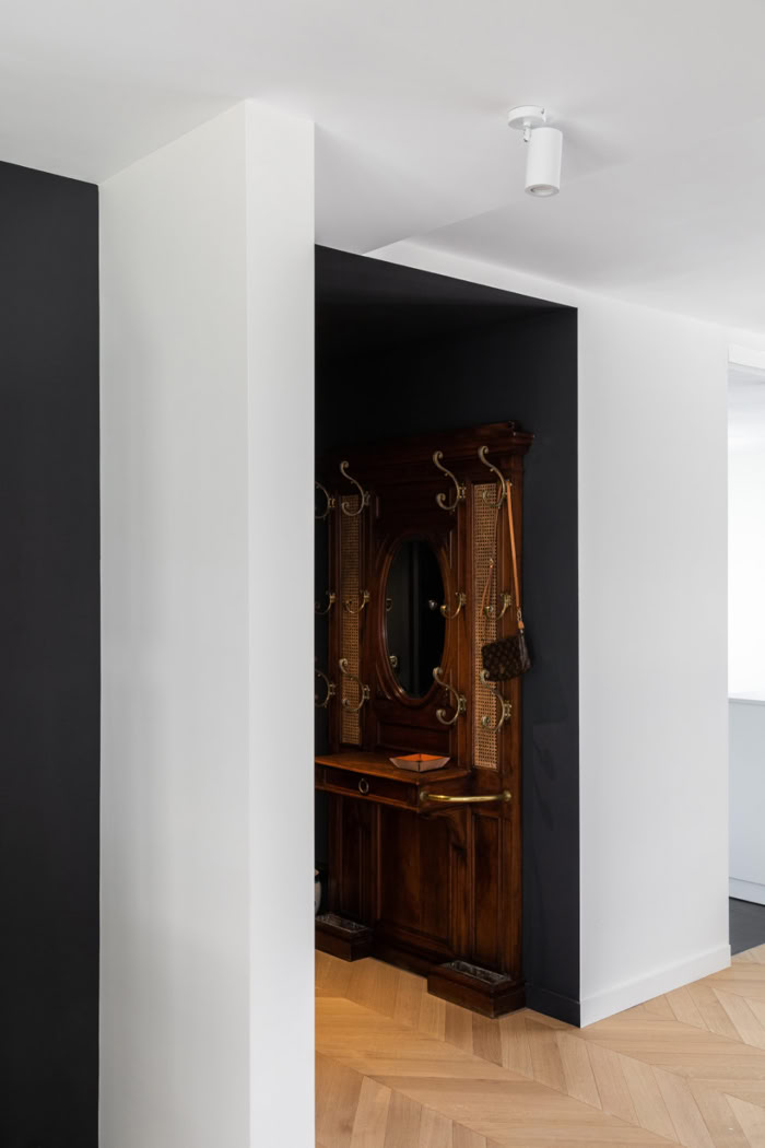 Aménagement d'une entrée avec vestiaire et miroir anciens, créant un effet de surprise dès l'arrivée.