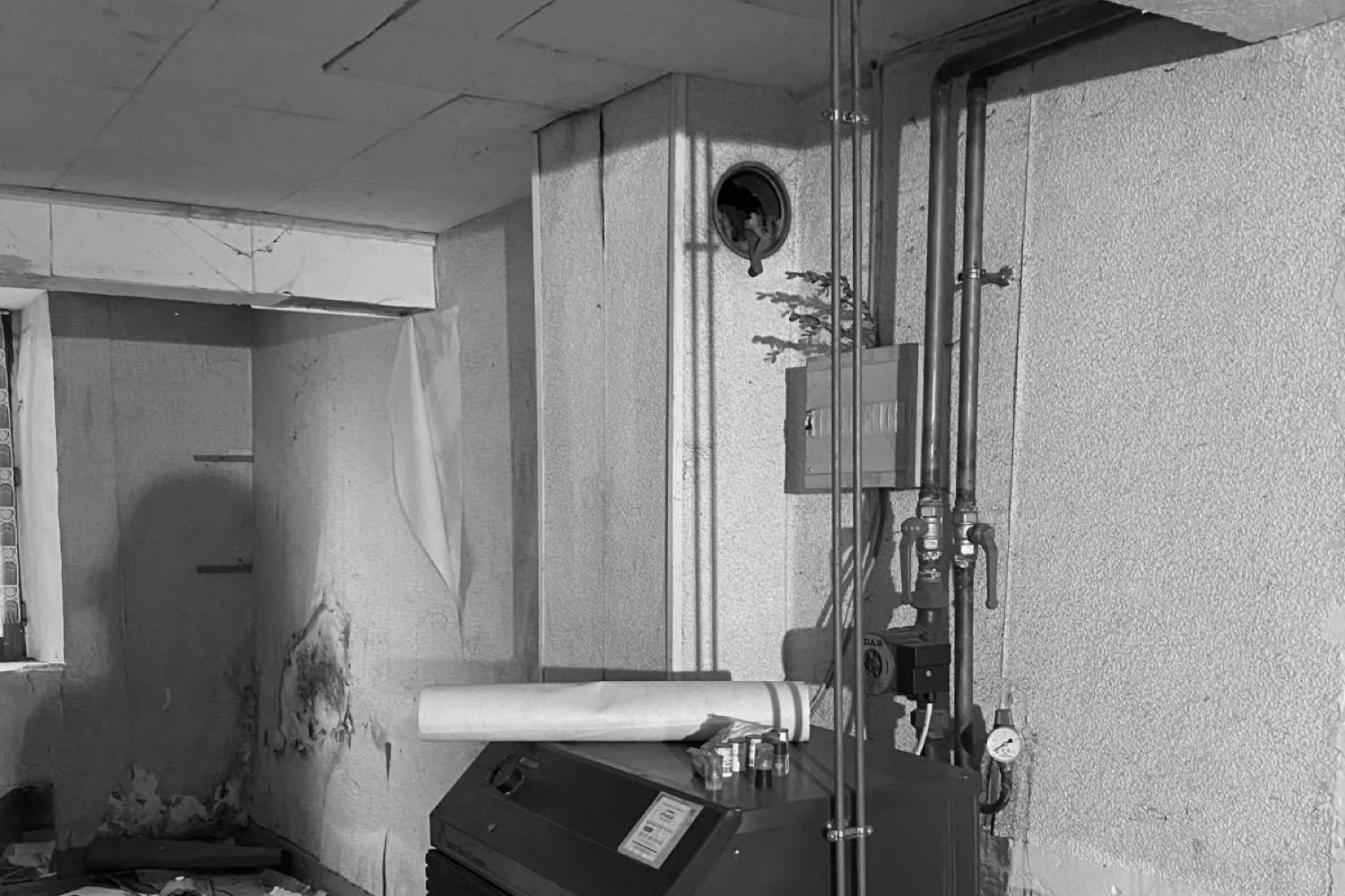 Ancienne chaudière au fioul et réseaux de plomberie vétustes avant rénovation énergétique en Moselle.