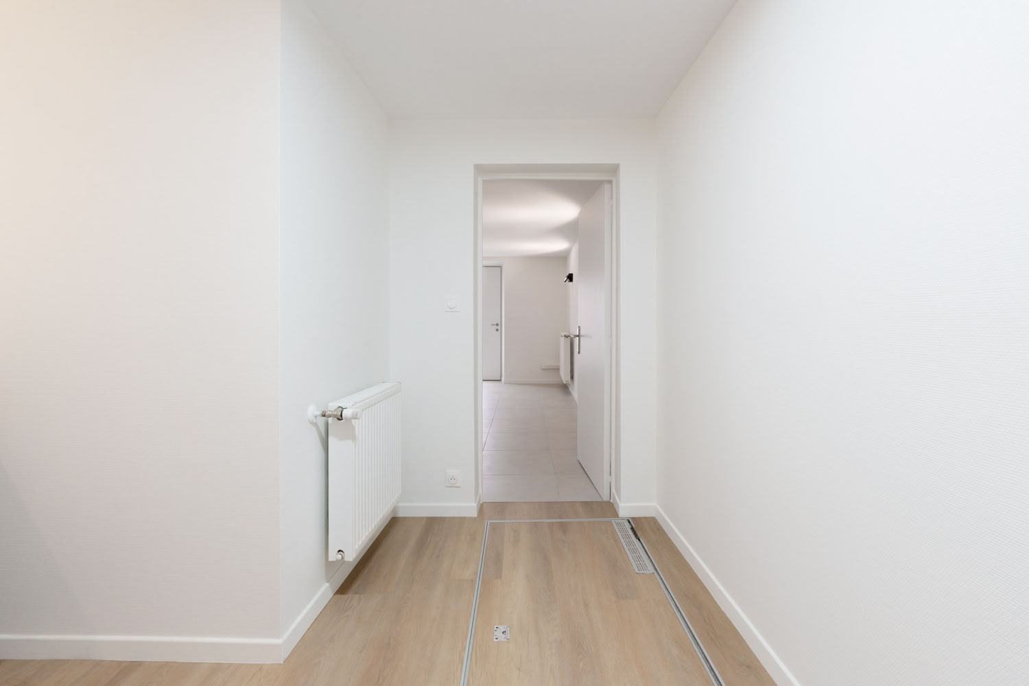 Couloir épuré avec accès sécurisé à la cave, projet de réhabilitation en Moselle.