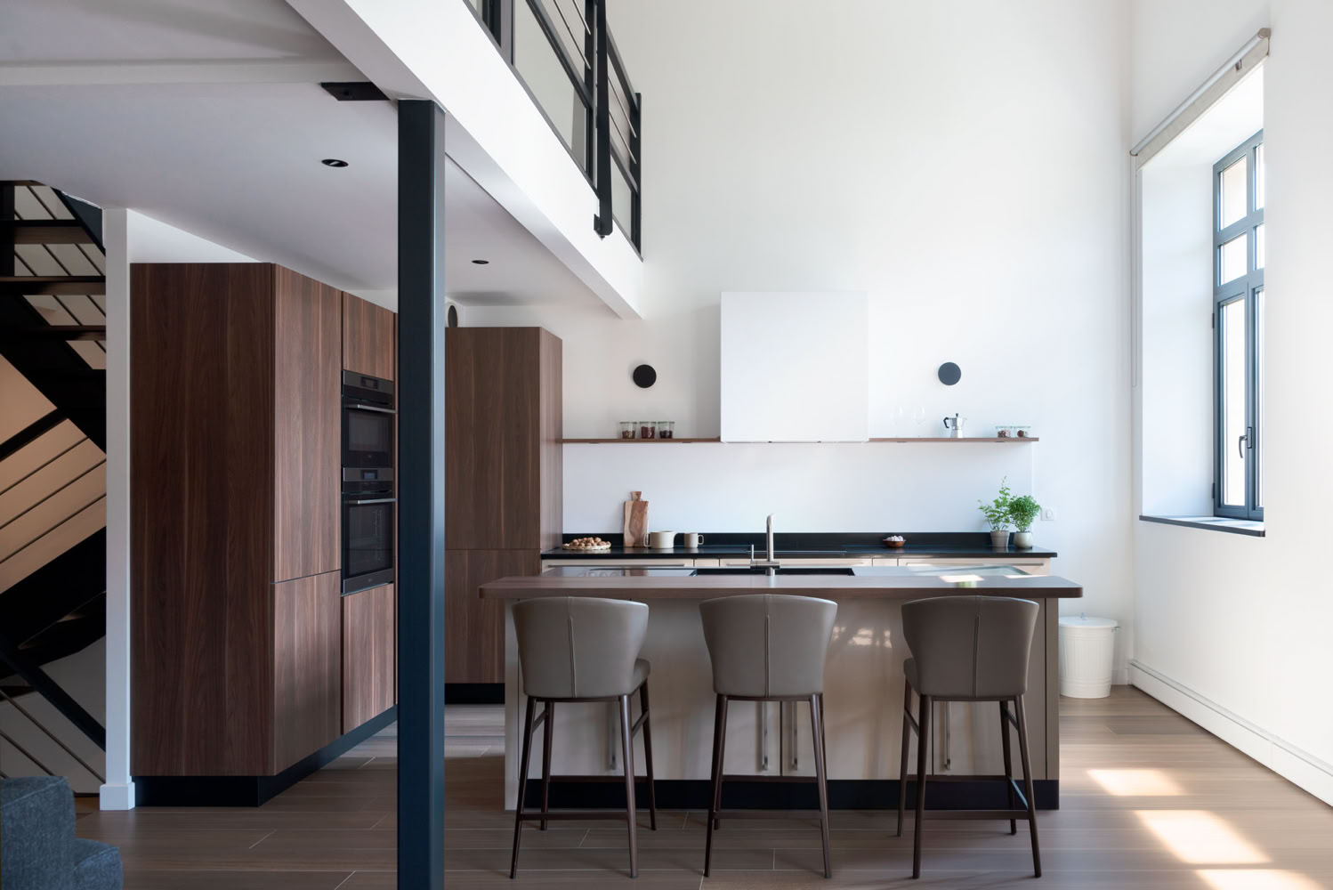 Cuisine design bois et noir avec îlot central, projet rénovation caserne Thionville par Guillaume Steffanus, architecte d'intérieur Moselle.