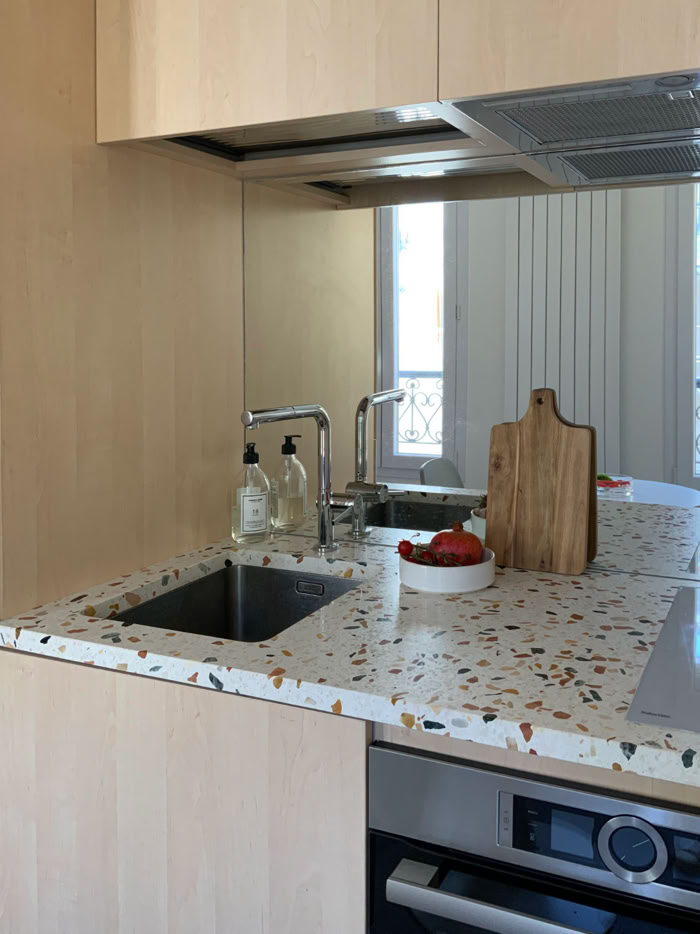 Détail de la cuisine compacte avec crédence miroir et robinetterie professionnelle par Guillaume Steffanus.