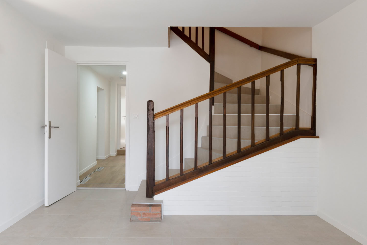 Entrée épurée et lumineuse avec escalier en bois d'origine, rénovation maison de village Metz.