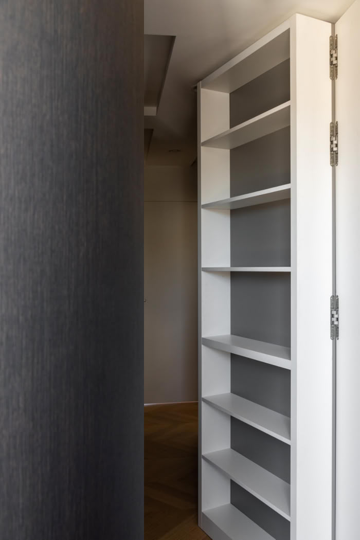 Zoom sur la porte dérobée sur mesure, illustrant la précision de la menuiserie intérieure.