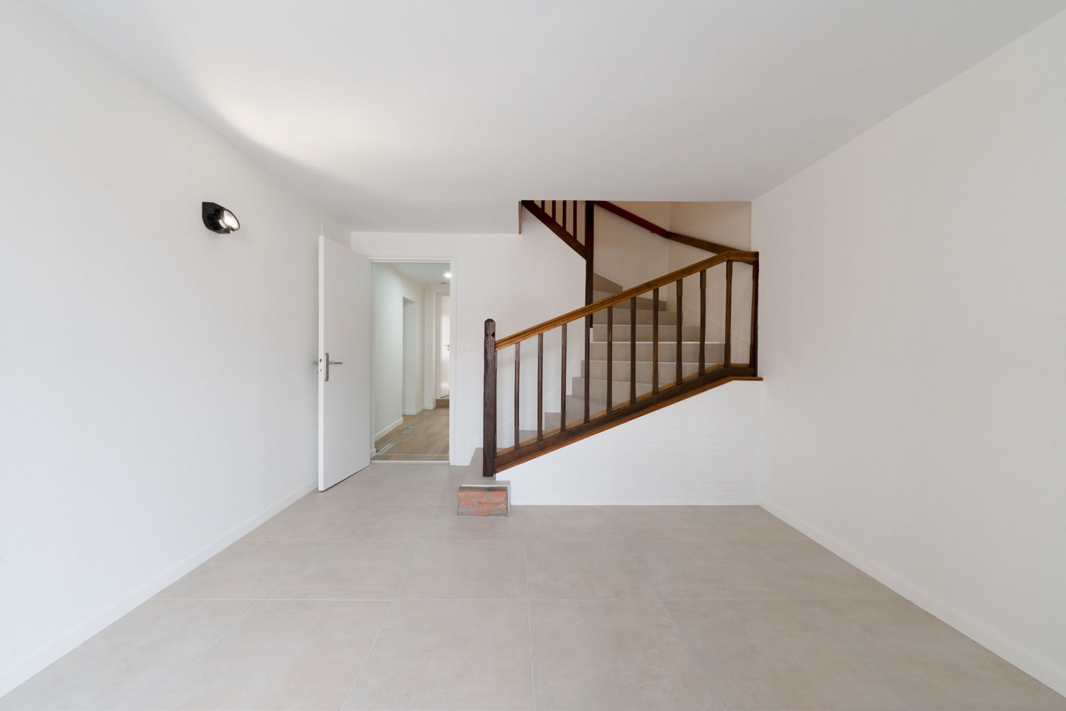 Entrée épurée et lumineuse avec escalier en bois d'origine, rénovation maison de village Metz.