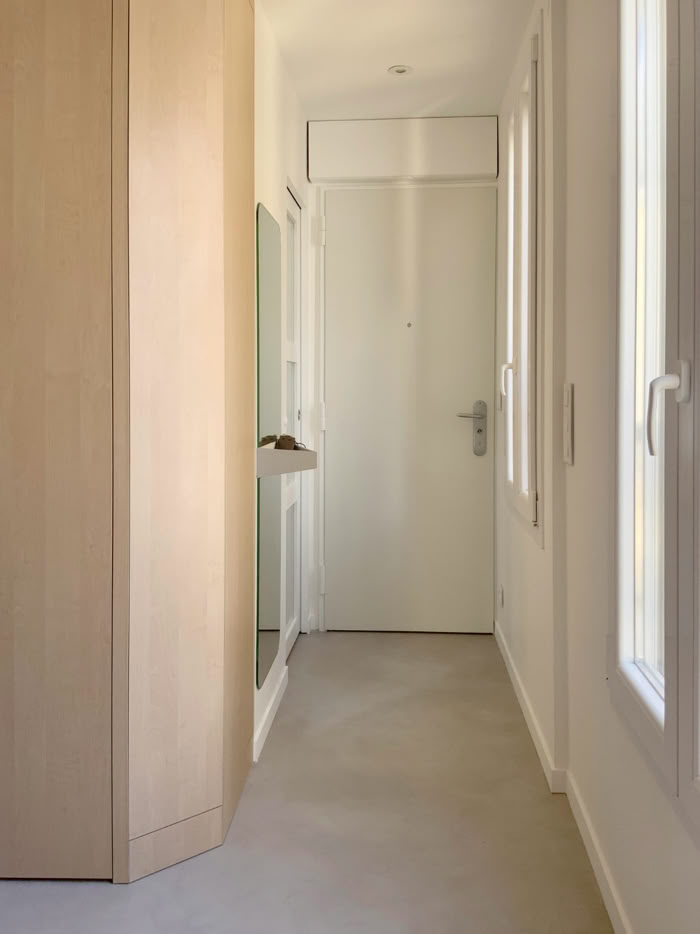 Aménagement d'entrée fonctionnel avec miroir, vide-poche et étendoir à linge escamotable invisible.