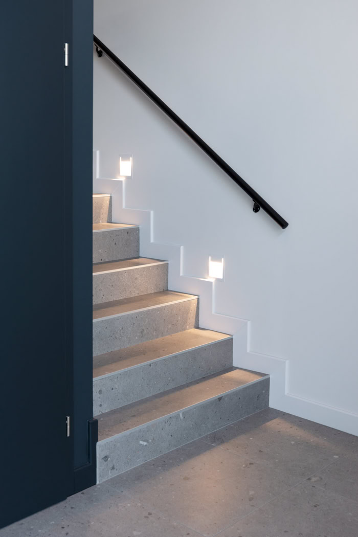 Escalier en béton avec éclairage LED intégré et main courante noire, design architectural moderne Thionville.