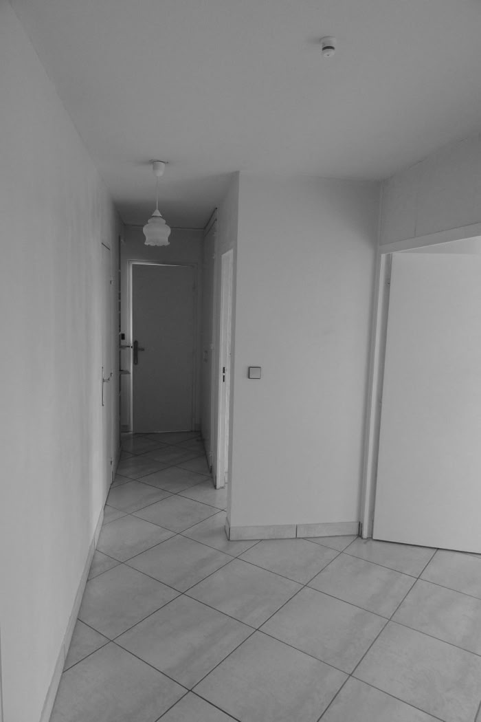 Couloir sombre avec carrelage ancien avant restructuration complète.