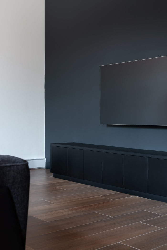 Meuble TV sur mesure noir mat et mur d'accent gris anthracite, décoration intérieure sobre et chic à Metz.
