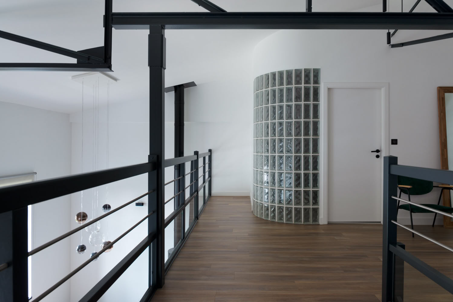 Mezzanine avec garde-corps noir et cloison en pavés de verre, par Guillaume Steffanus, architecte d'intérieur lumineuse en Moselle.