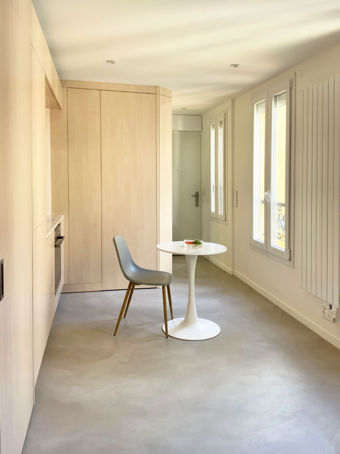 Aménagement d'un studio mettant en valeur l'enfilade de fenêtres et la luminosité naturelle.