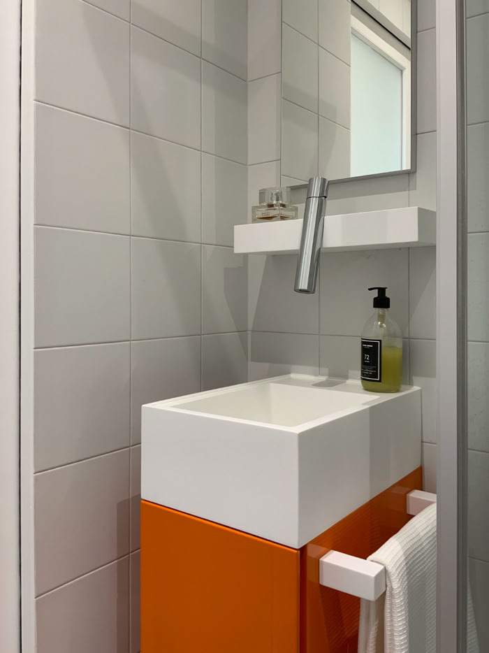 Salle de douche de moins de 2 m² avec porte en verre dépoli et robinetterie haut de gamme.