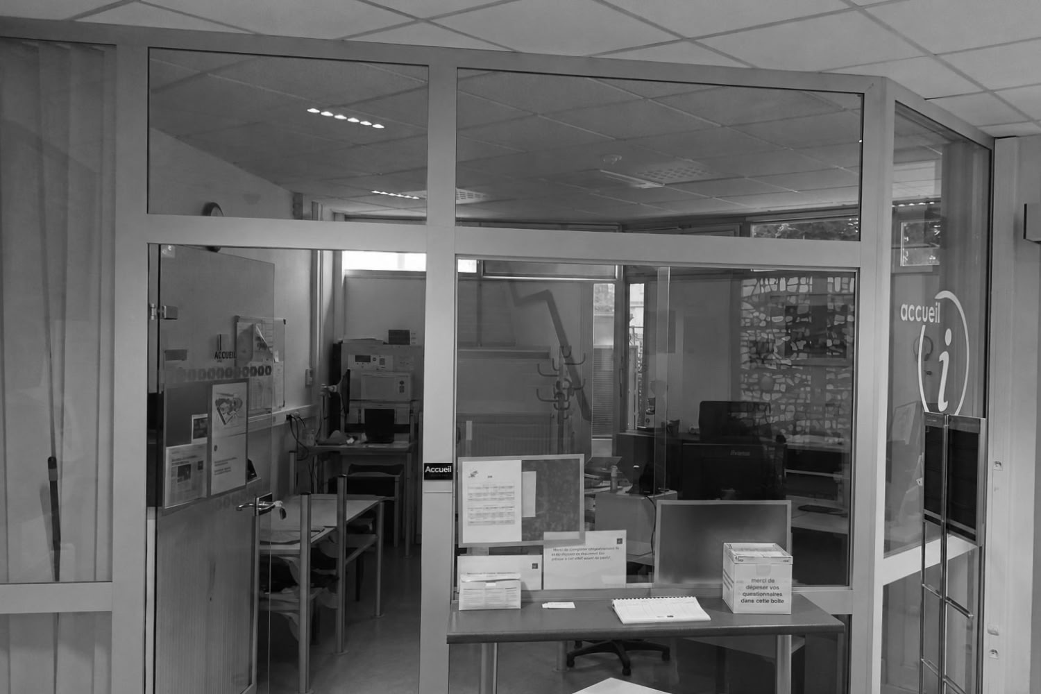 Vue d'ensemble de l'espace d'accueil existant, avec bureaux en arrière-plan.