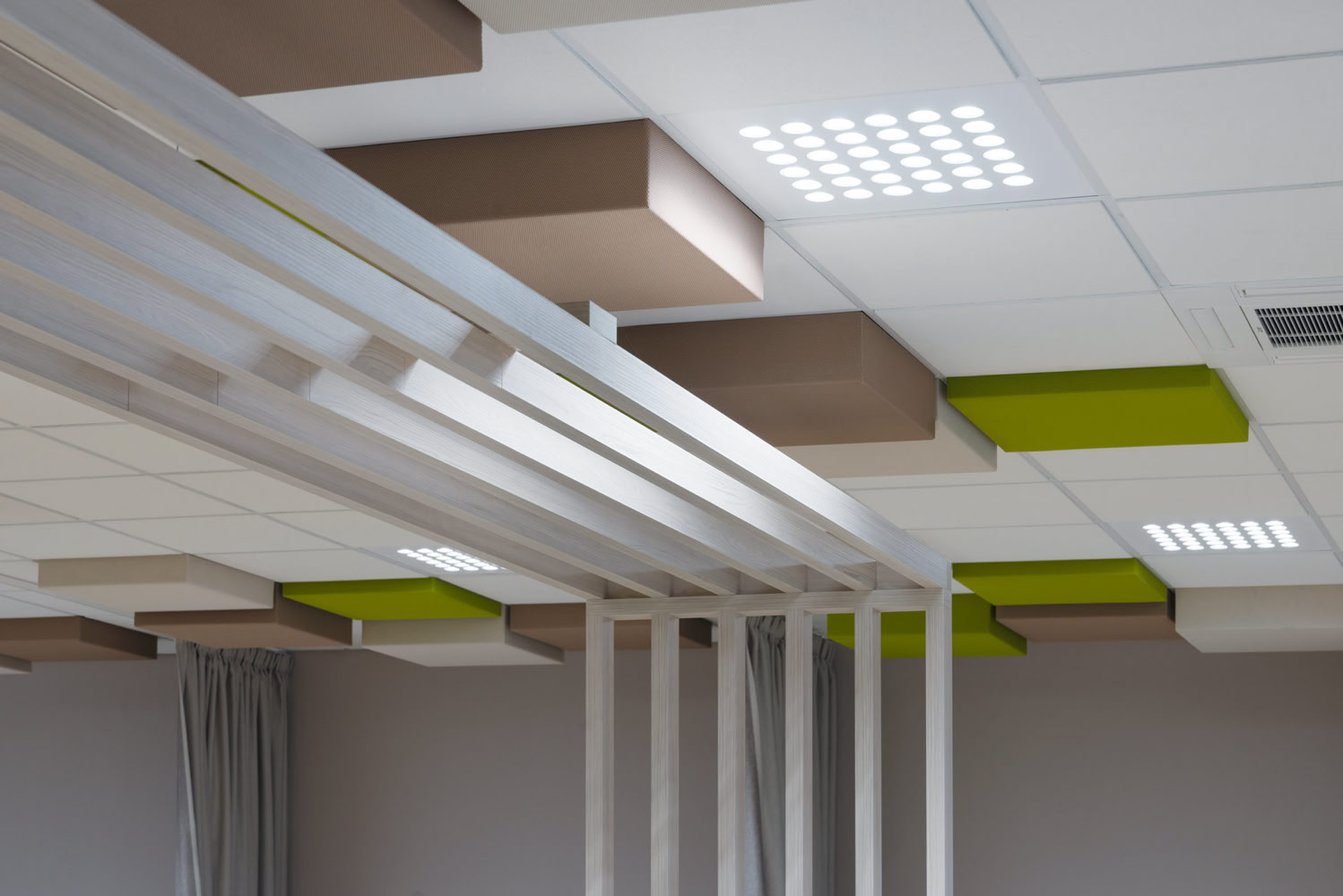 Traitement acoustique design au plafond avec panneaux suspendus verts et bois, rénovation technique ERP à Metz. 