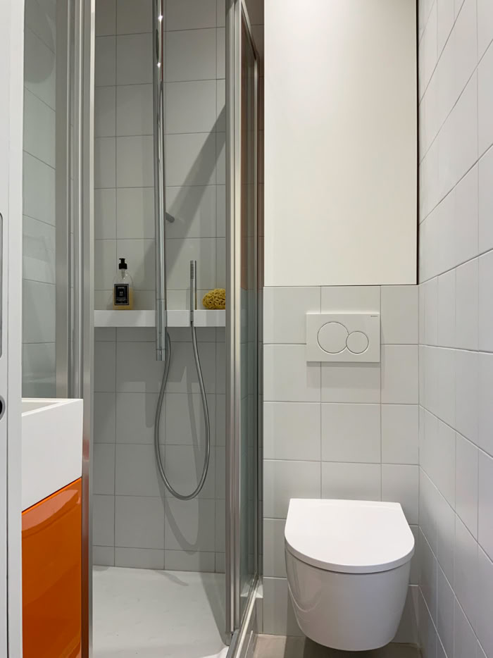 Mobilier de rangement sur mesure au-dessus du bâti-support pour maximiser l'espace en salle de bain.