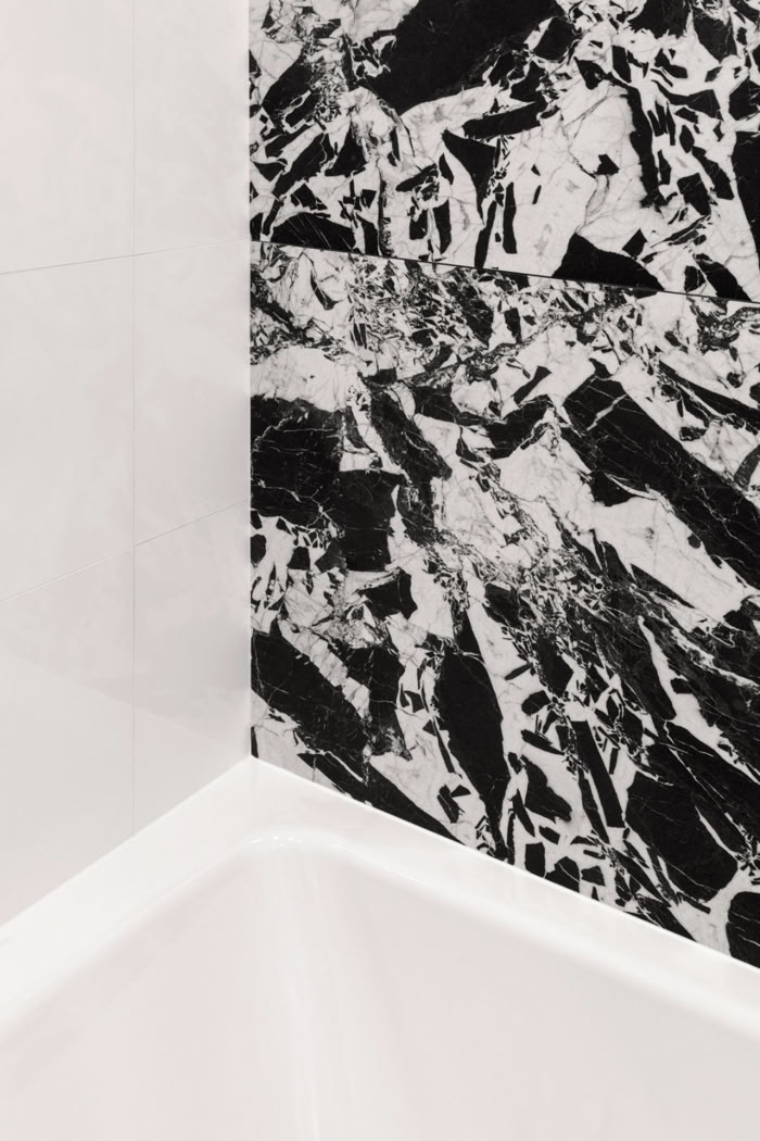 Détail soigné de la baignoire et du carrelage dans une salle d'eau rénovée avec des finitions de standing.