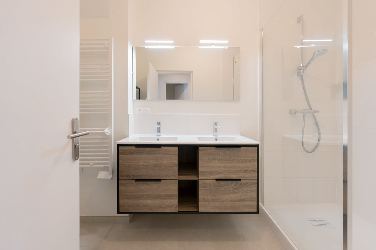 Aménagement salle de bain moderne avec double vasque bois et douche à l'italienne à Metz.
