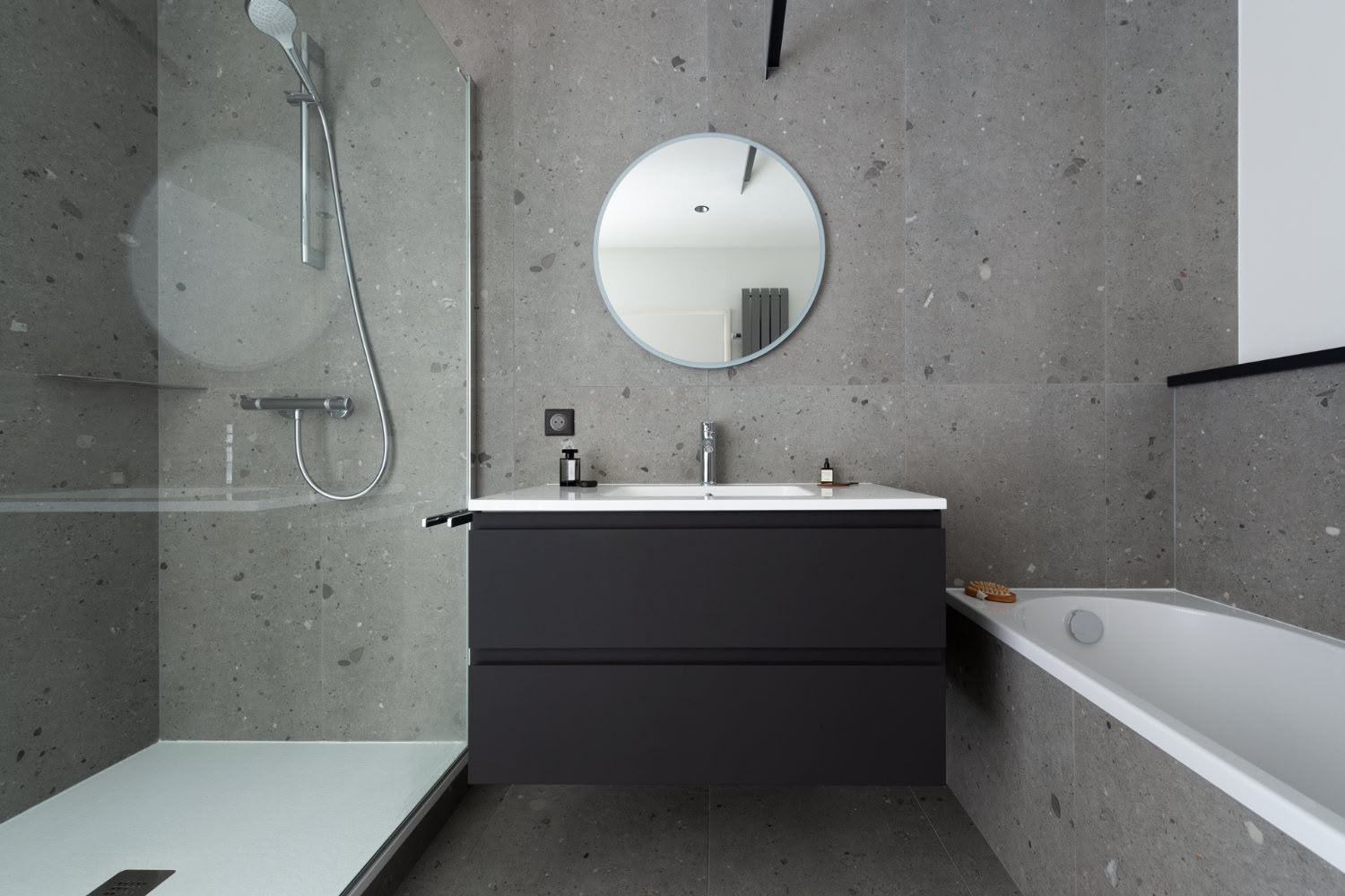 Salle de bain minimaliste grise avec baignoire et paroi de douche, design épuré par architecte d'intérieur Metz.