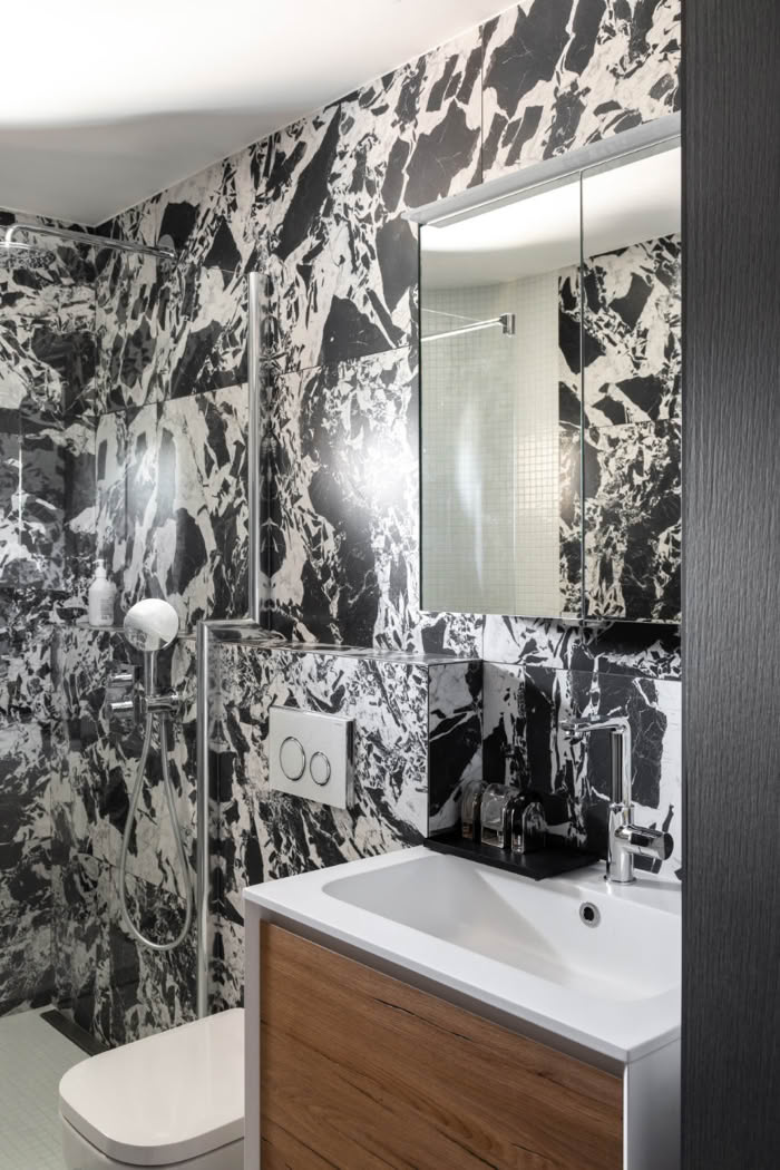 Salle de bain sur mesure alliant un graphisme marbre noir et blanc à la chaleur du bois.