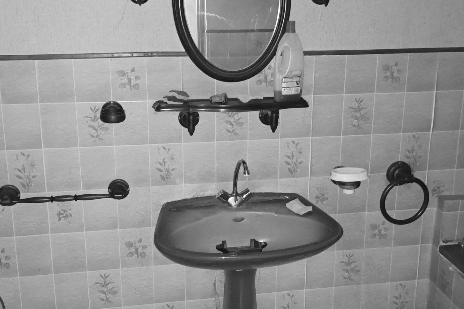 Salle de bain ancienne avec lavabo colonne rose et carrelage vert, état initial avant travaux à Metz.