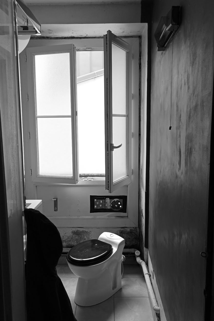 Salle de douche avant rénovation complète : équipements obsolètes et manque de luminosité.